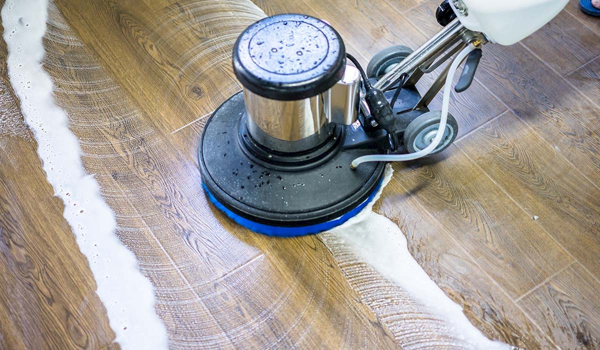 a wooden file floor being deep cleaned by a power scrubber
