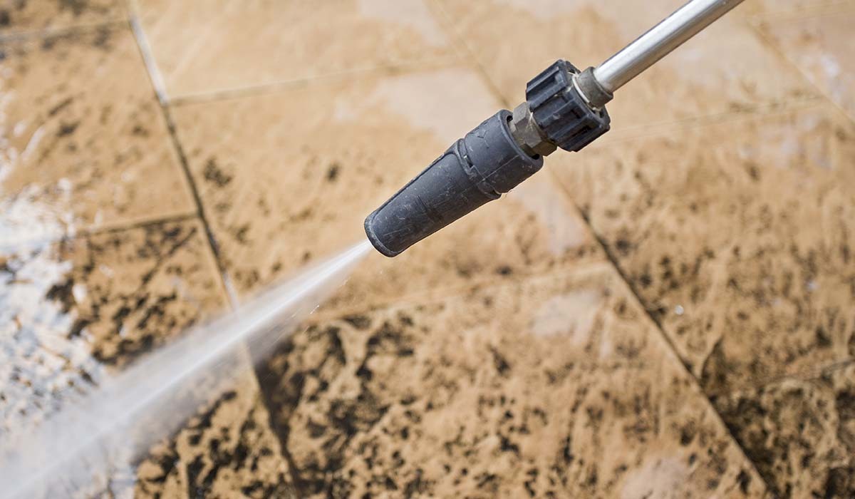a high pressure nozzle removing mold from a water damaged tile floor